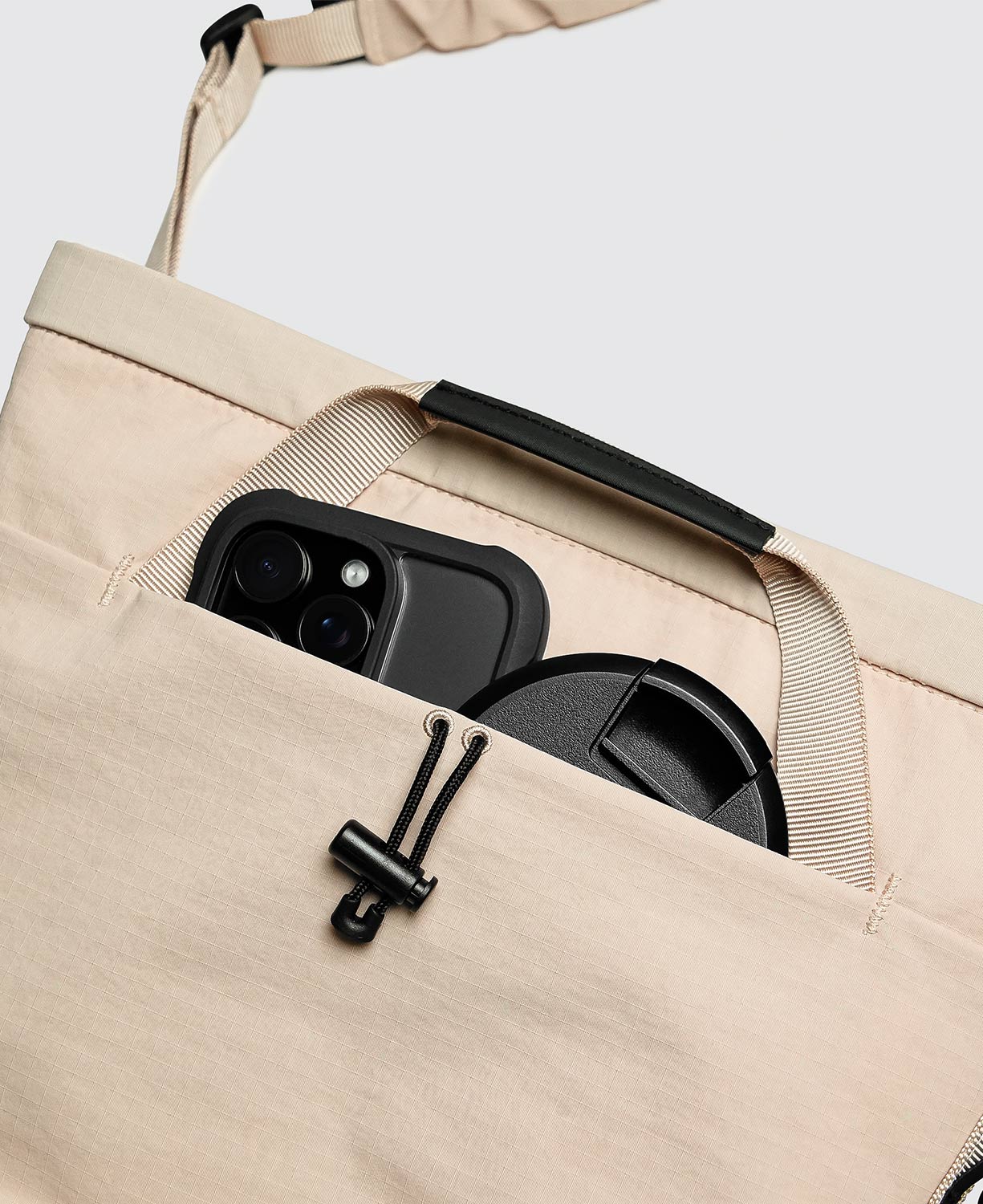 背面短提把採用TPU加厚材質，手感舒適且耐用，不需要使用時可收納於隱藏式口袋內。